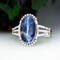 front view large blue with white veining oval sodalite jasper stone bezel set accented with beads and stamped cutout wire on a 3 wire cuff